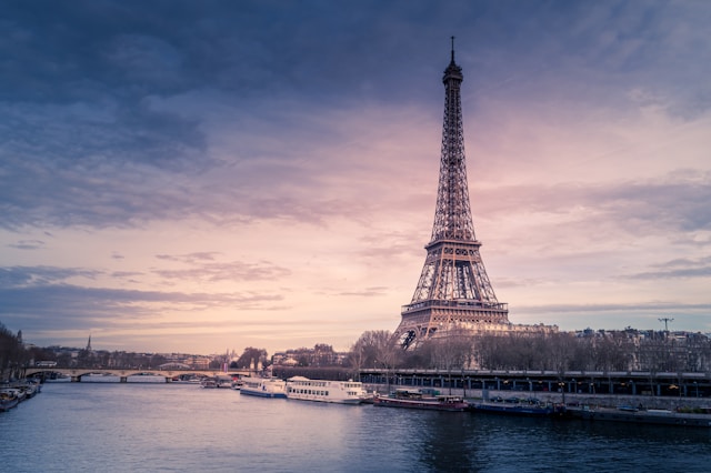 The Eiffel Tower in Paris at sunset, with the River Seine in the foreground.