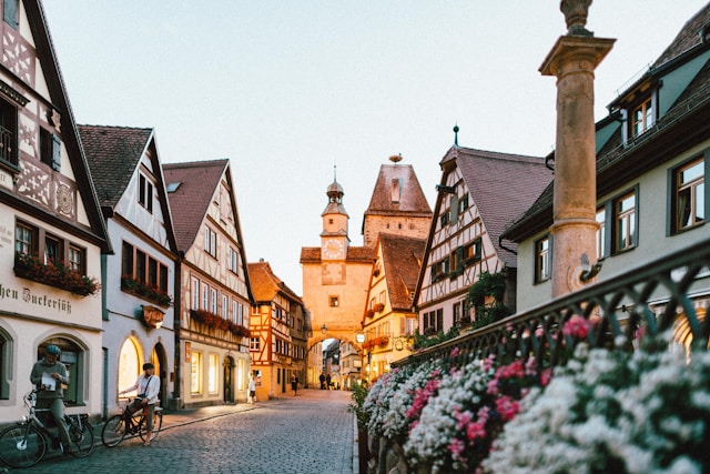 Historic street in Rothenburg ob der Tauber, Germany, with half-timbered houses, flowers and warm evening light.
